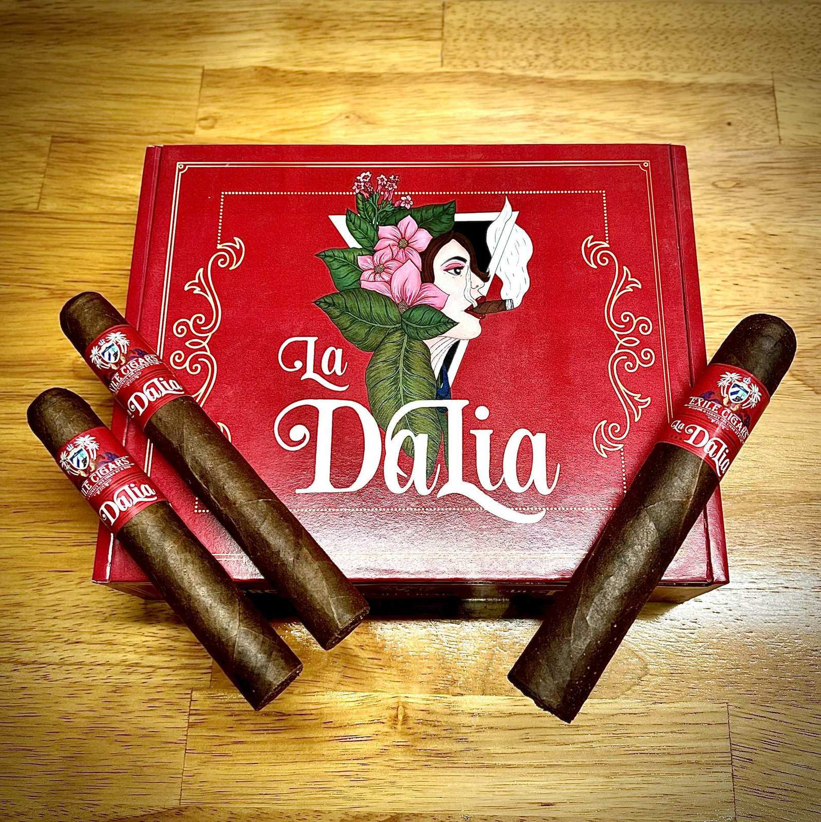Four Exile Cigars fanned out beside an open La Dalia box on a wood table
