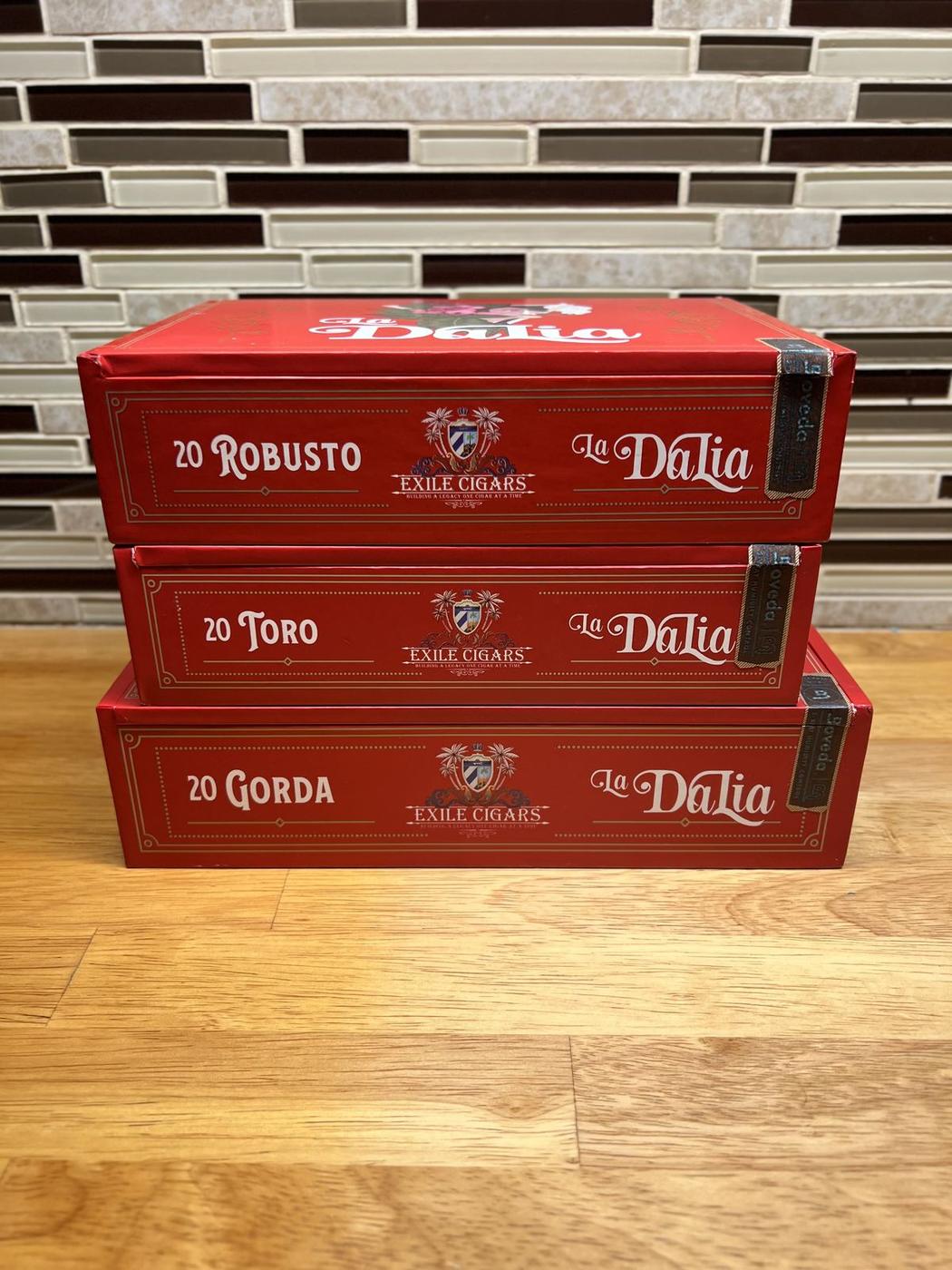 Three La Dalia vitola boxes, Robusto, Toro, and Gorda, stacked and showing the Exile Cigars crest