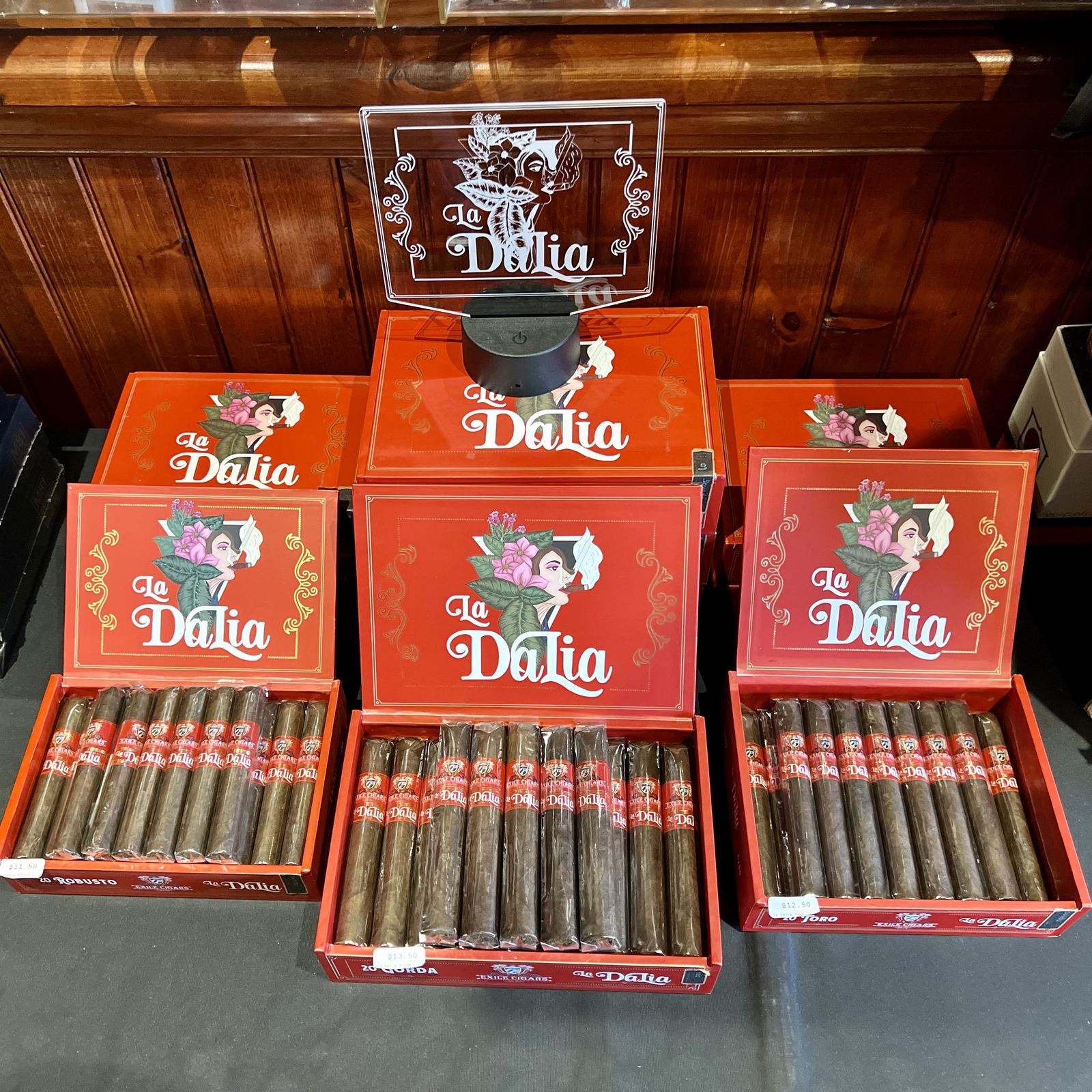 La Dalia cigar boxes displayed in a warm, wood-paneled cabinet